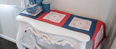 blue and red table runner made of squares on white side table