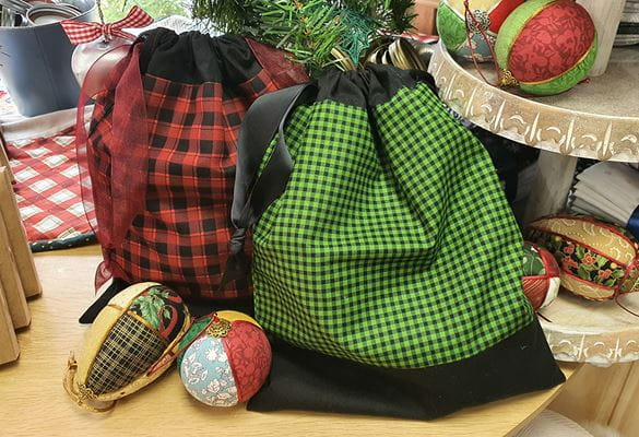 Red and green drawstring bags between Christmas decorations