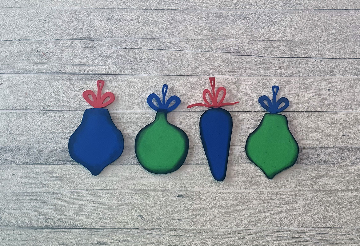 4 blue and green foam baubles on wood background