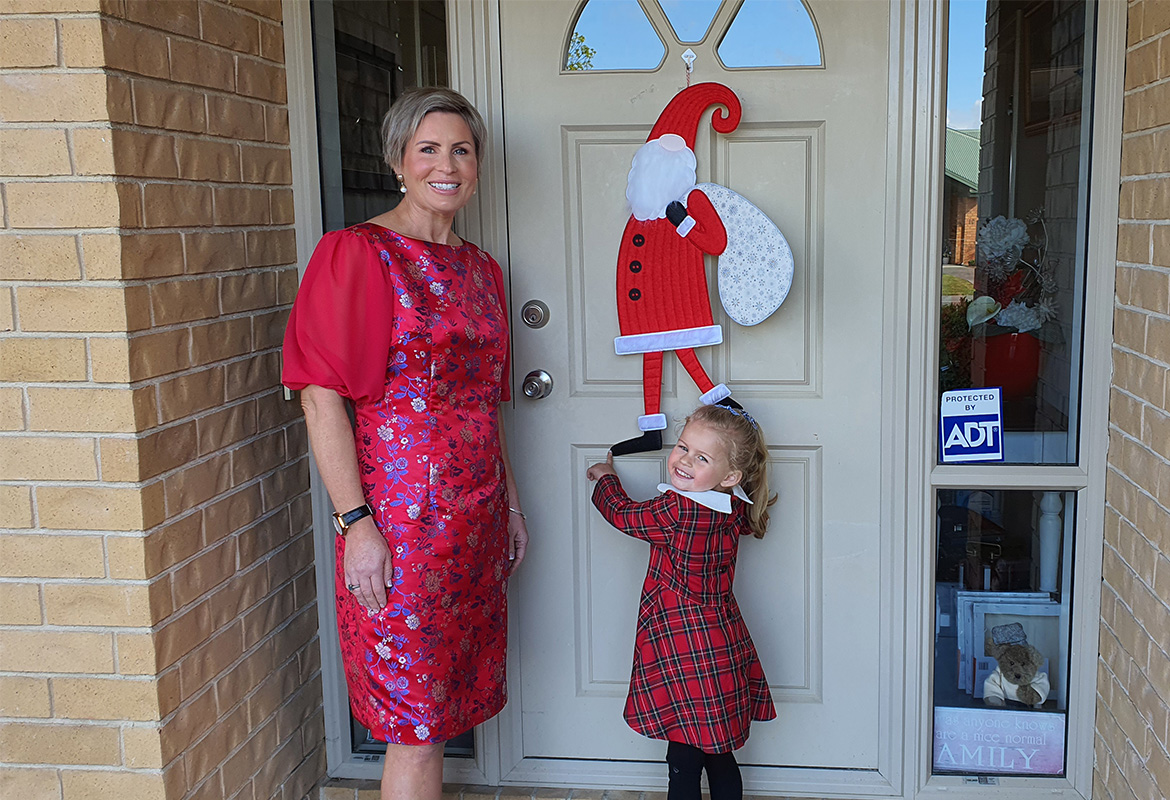 Mom, daughter in front of door with Santa hanging