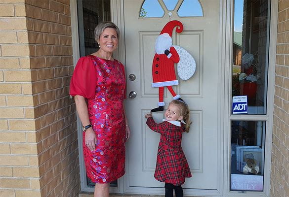 Mom, daughter in front of door with Santa hanging
