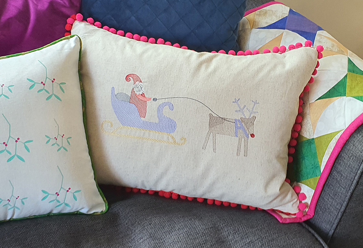 Embroidered Santa on sleigh with reindeer cushion