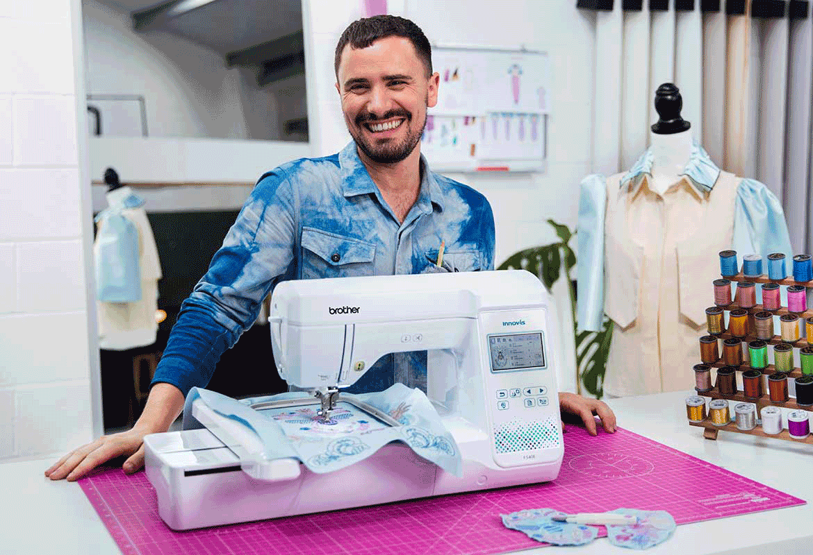Young man standing behind Brother F540E in bright sewing room