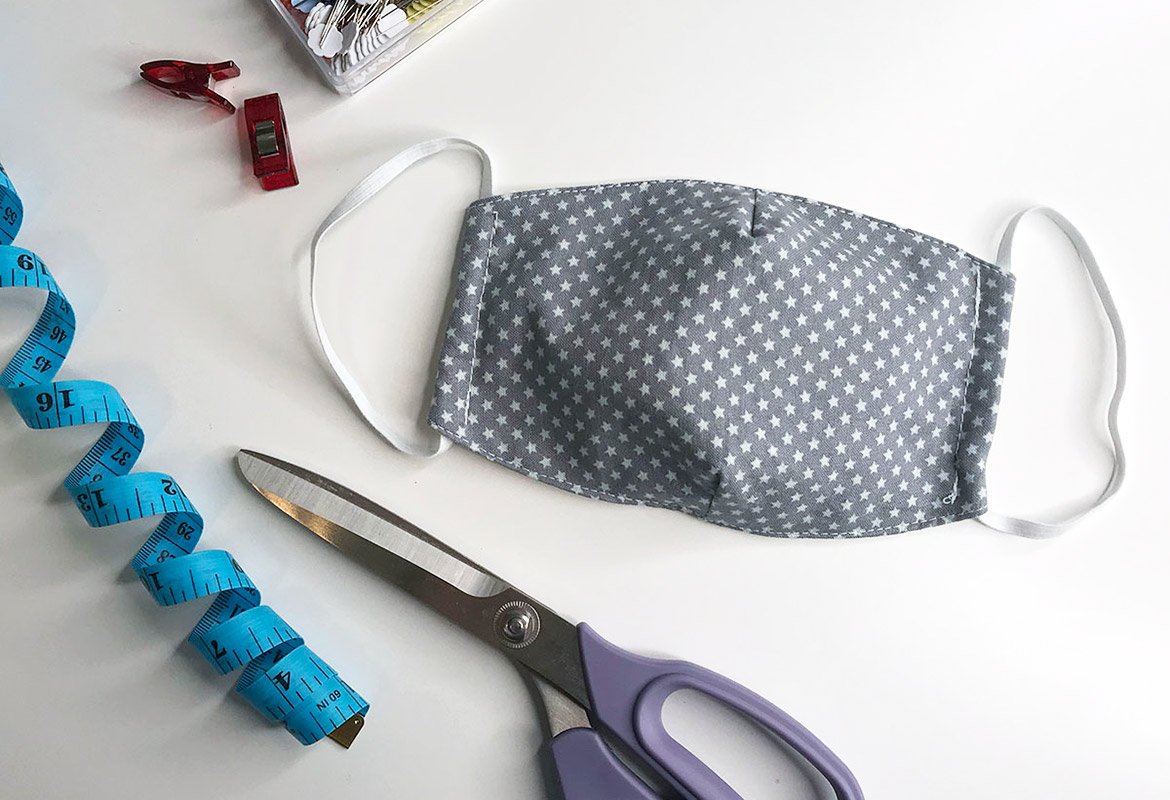 Blaue Stoffmaske mit Schere und Blauem Maßband