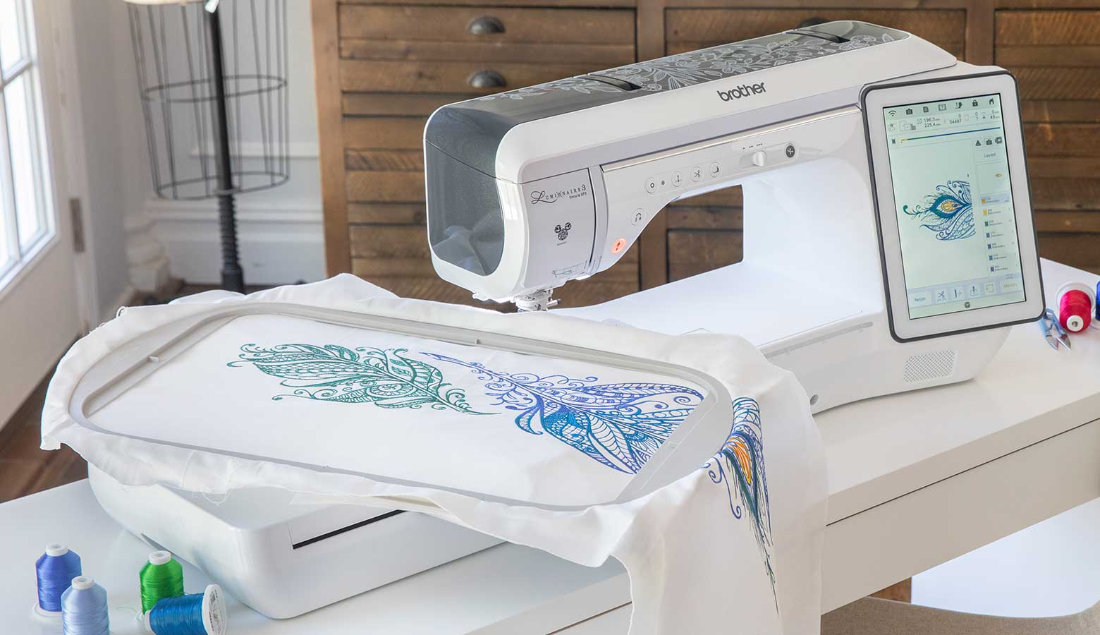 Large blue embroidery in frame next to embroidery machine