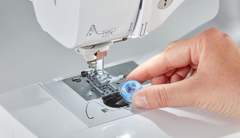 Het laten vallen van de blauwe spoel in de Brother naaimachine uit de A-serie