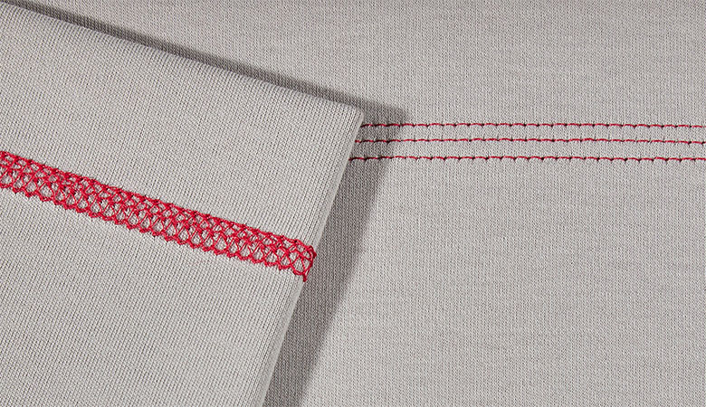 Gros plan du point de recouvrement triple rouge sur tissu gris