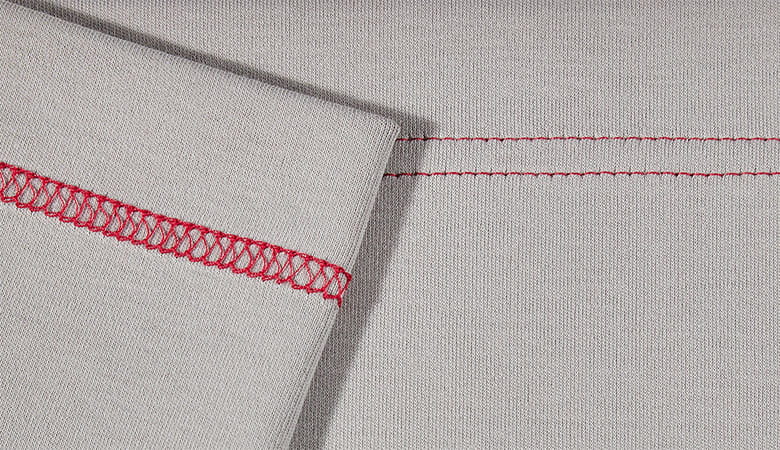 Red wide cover stitch on grey fabric