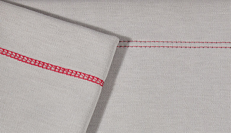 Gros plan du point de recouvrement étroit rouge sur tissu gris