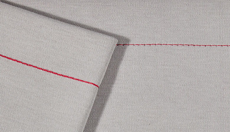 Red chain stitch on grey fabric