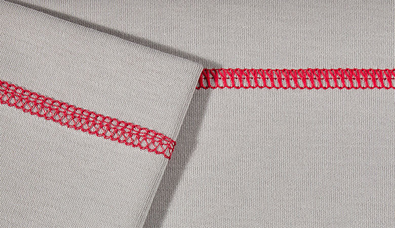 Gros plan du point de recouvrement triple rouge sur tissu gris