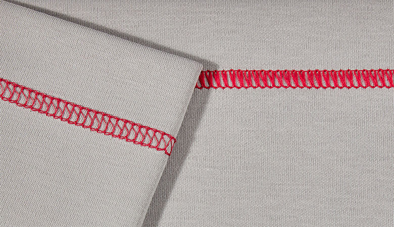 Gros plan du point de recouvrement triple rouge sur tissu gris