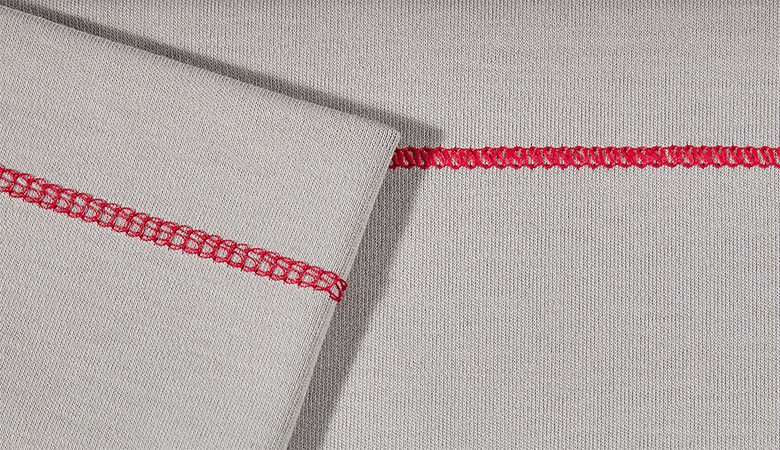 Close up of red top cover stitch sur tissu gris