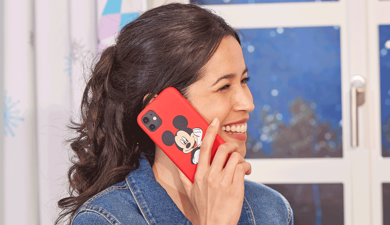 Dame parlant sur un mobile rouge avec un visage de Mickey Mouse dessus