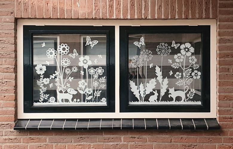 Nahaufnahme von Weißen Fensteraufklebern mit Blumen und Tieren