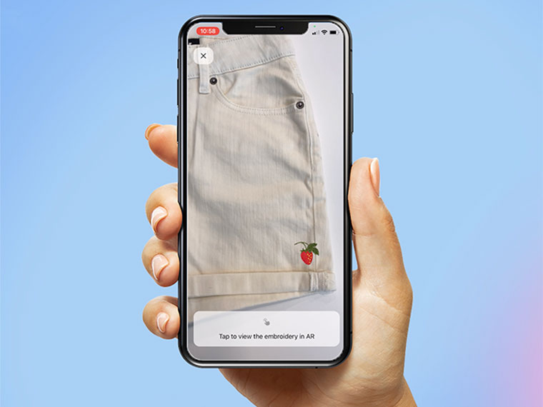 Mano con telefono cellulare su sfondo blu chiaro