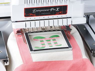 Wit met roze tas in klemraam PRCLP100B op borduurmachine
