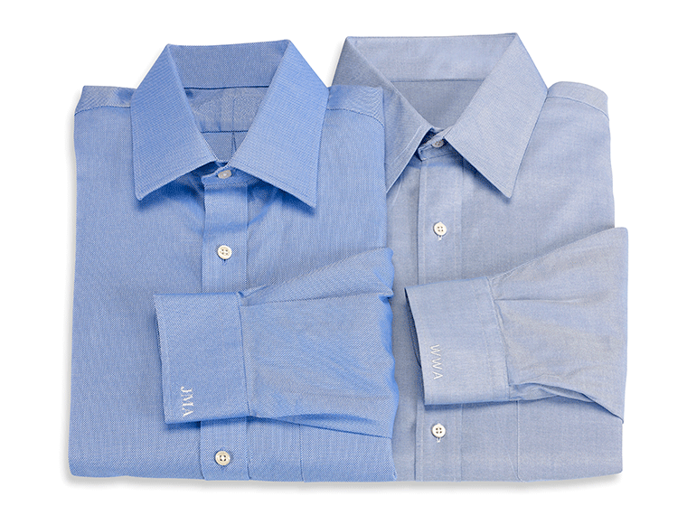 Blue formal shirts with white initials embroidered on cuffs
