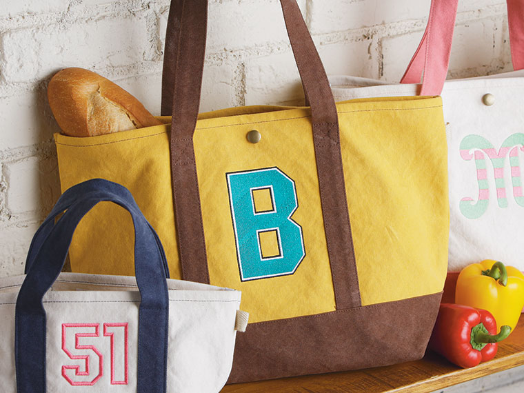 Gelbe und weiße Taschen mit gestickten Buchstaben und Zahlen