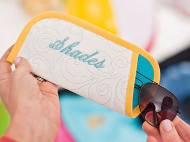 Sunglass case with blue embroidery on