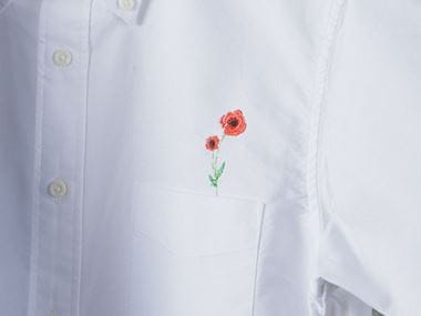 Красный цветочек вышитый на белой рубашке
