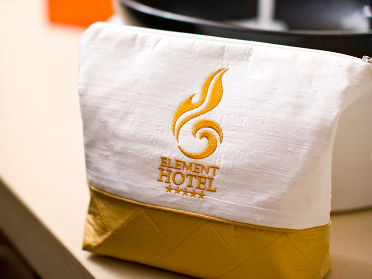 white and gold toiletry bag with embroidered logo
