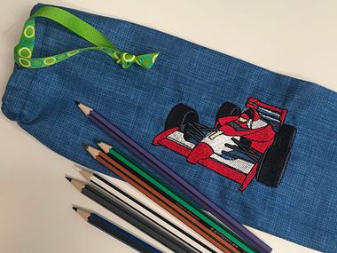 Red racecar embroidery on dark blue pencil case with pencils