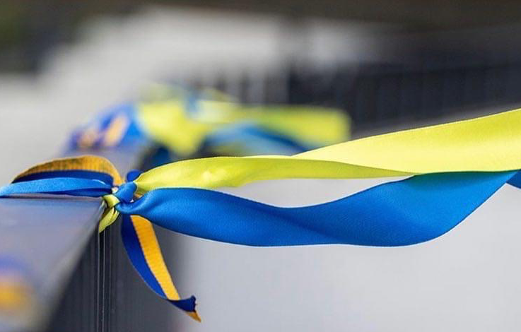 Blue and yellow ribbons tied to a handrail