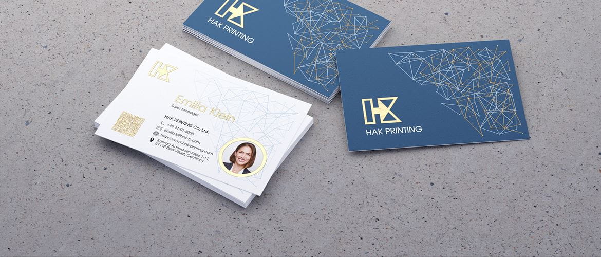 Business cards printed with gold foil, lying on a concrete surface