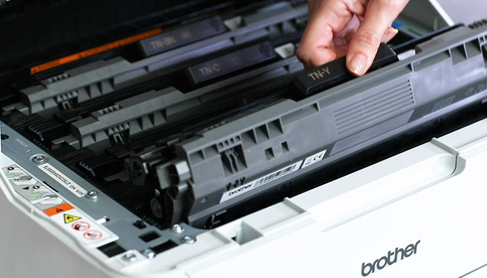 Close up of the inside of a Brother printer with a toner being inserted inside
