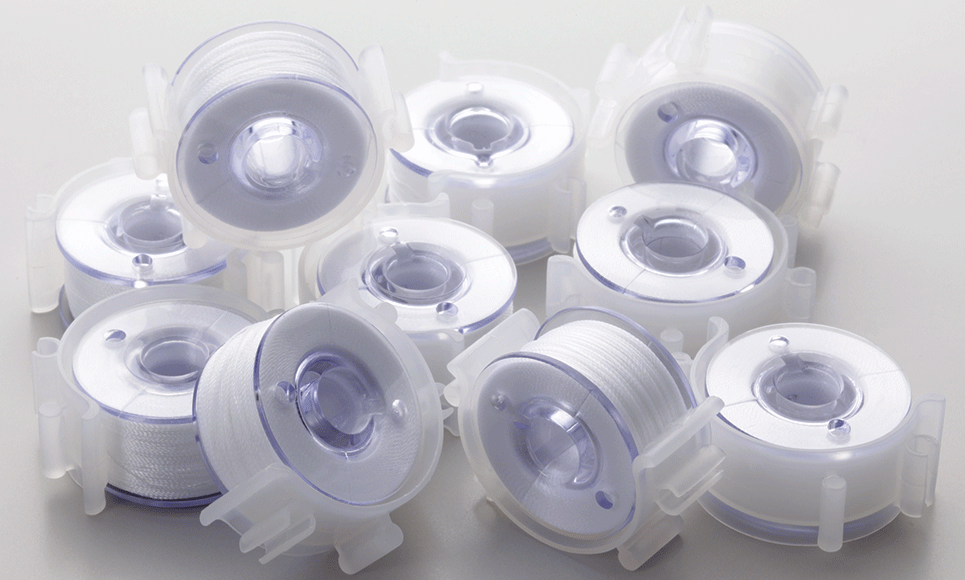 Multiple pre-wound machine bobbins PWB60 and clips with white thread