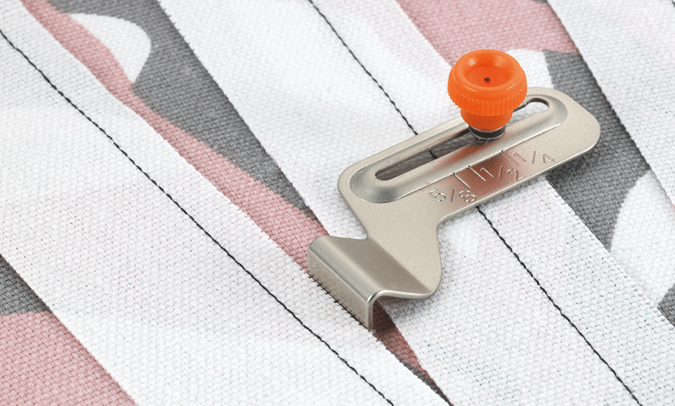 Metal seam guide SG1 with orange guide button on white fabric strips